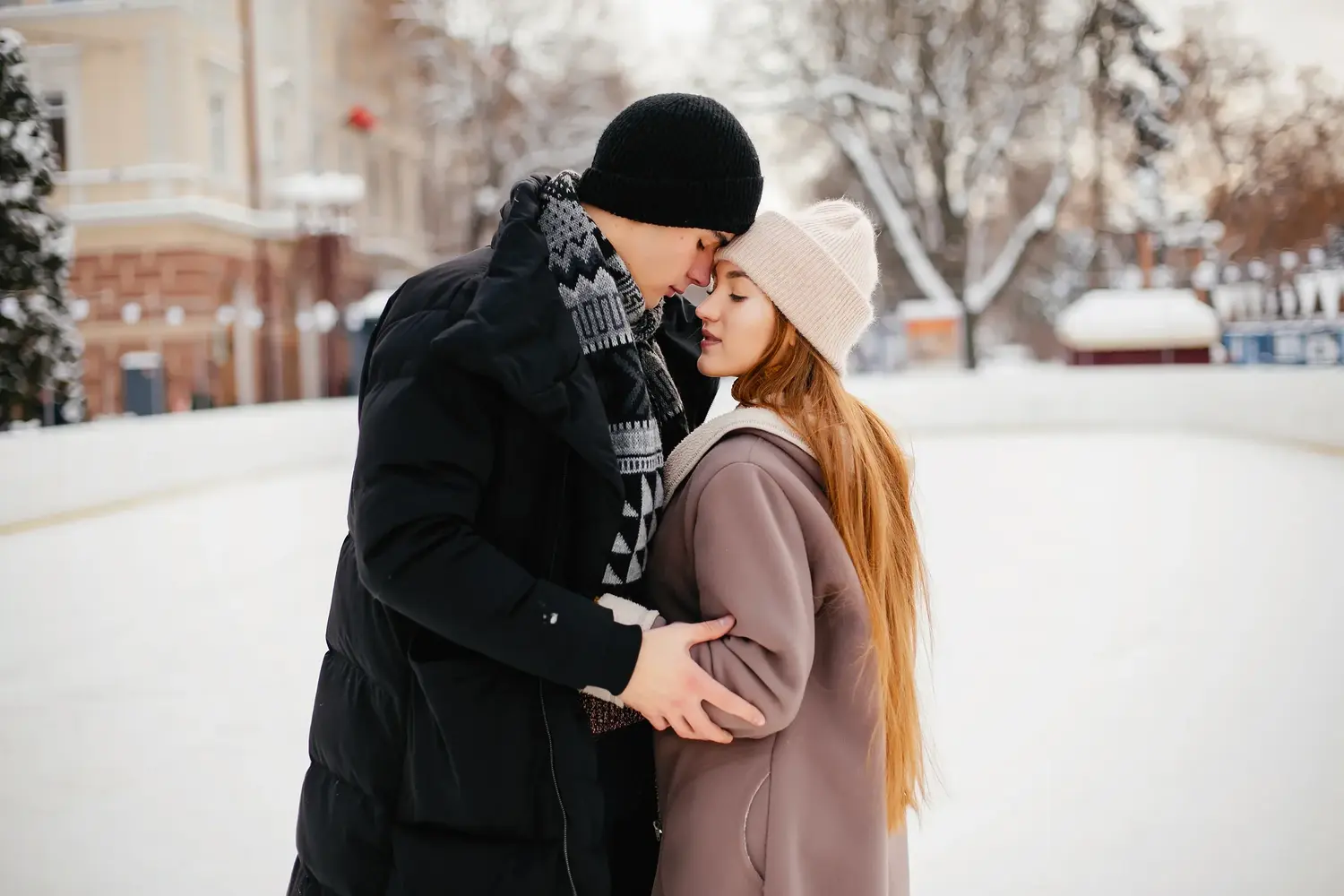 Couple embracing in a snowy park during winter