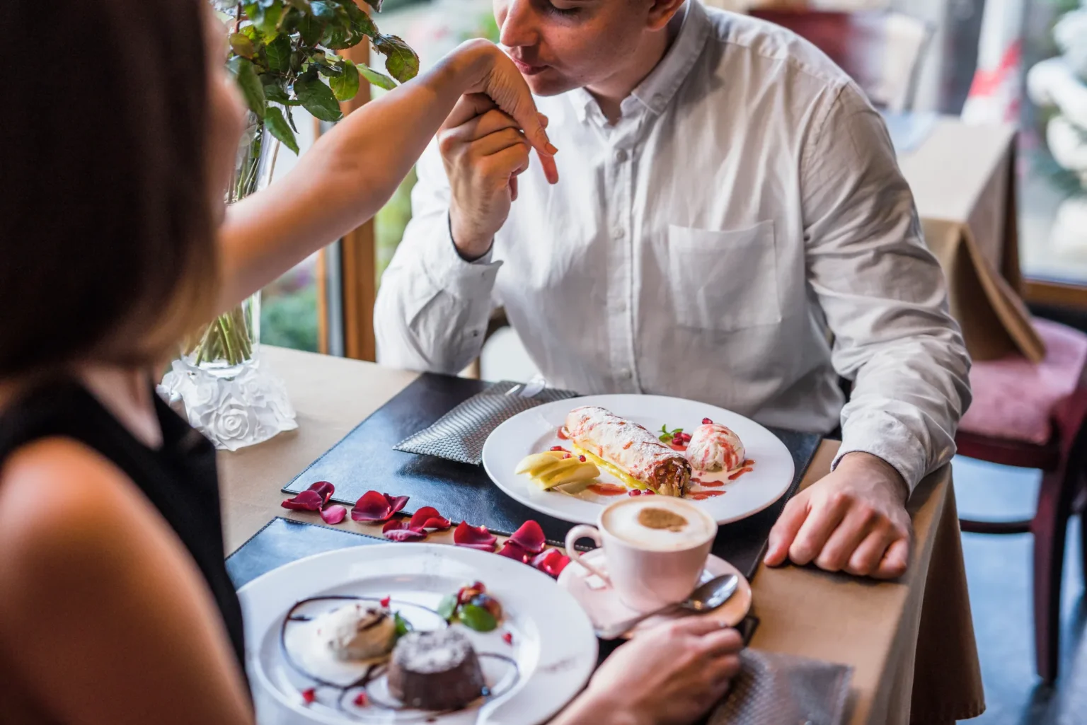 Couple sharing desserts and coffee during a café date