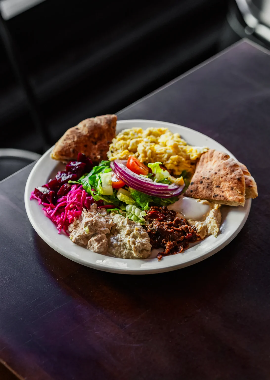 Mediterranean breakfast platter with scrambled eggs, hummus, salad, and pita at Effy’s Café